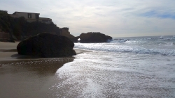 Natural rock arch standing along the sand in Laguna Beach